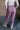Back view of model wearing the Myla Vintage Purple Drawstring Jogger Pants which features light purple waffle knit fabric, two front pockets, an elastic waistband with drawstring ties, and jogger pant legs with thick hem.