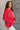 Side view of model wearing the Merry Red Ribbed Long Sleeve Sweater which features red and light red ribbed fabric, thick hem, a round neckline, a graphic that says "MERRY" in white outline, dropped shoulders, and long sleeves with ribbed cuffs.
