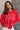 Front view of model wearing the Merry Red Ribbed Long Sleeve Sweater which features red and light red ribbed fabric, thick hem, a round neckline, a graphic that says "MERRY" in white outline, dropped shoulders, and long sleeves with ribbed cuffs.