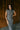 Upper front view of model wearing the Alianna Silver Shimmer Cowl Neck Midi Dress that has grey and silver shimmer fabric, midi length, ruched side details, a slit on the side, a slight cowl high neckline, and a sleeveless design.