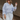 Front view of model wearing the Selene Light Blue Long Sleeve Top which features light blue light weight fabric, v-neckline with collar and long sleeves with an open key hole and cinched details.