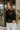 Front view of model wearing the Abby Black Lace Long Sleeve Top that has black sheer fabric, monochrome lace floral pattern, lettuce hem details, a high neck and long sleeves.