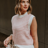 Side view of model wearing the Sophia Pink & White Sleeveless Sweater which features pink and white knit fabric, mini geometric pattern, white ribbed hem, round neckline and sleeveless.