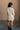 Full body back view of model wearing the Adley Cream Cable Knit Sweater Dress that has a thick cable knit design, ribbed hem, mini length, a round neck, and long balloon sleeves.