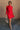 Full body front view of model wearing the Melina Red Turtleneck Sweater Dress that has red ribbed knit fabric, a flared skirt, mini length, a turtleneck neckline, and long sleeves.