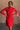 front view of model wearing the Melina Red Turtleneck Sweater Dress that has red ribbed knit fabric, a flared skirt, mini length, a turtleneck neckline, and long sleeves.