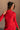 Upper front view of model wearing the Melina Red Turtleneck Sweater Dress that has red ribbed knit fabric, a flared skirt, mini length, a turtleneck neckline, and long sleeves.