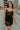 Front view of model wearing the Brielle Black Sequin Fringe Mini Dress which features black sheer fabric, black lining, mini length, black sequin fringe details, scooped neckline, adjustable straps, sleeveless and monochrome back zippper with hook closure
