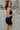 Side view of model wearing the Brielle Black Sequin Fringe Mini Dress which features black sheer fabric, black lining, mini length, black sequin fringe details, scooped neckline, adjustable straps, sleeveless and monochrome back zippper with hook closure.