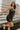 Front view of model wearing the Brielle Black Sequin Fringe Mini Dress which features black sheer fabric, black lining, mini length, black sequin fringe details, scooped neckline, adjustable straps, sleeveless and monochrome back zippper with hook closure