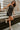 Full body view of model wearing the Brielle Black Sequin Fringe Mini Dress which features black sheer fabric, black lining, mini length, black sequin fringe details, scooped neckline, adjustable straps, sleeveless and monochrome back zippper with hook clo