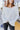 Close front view of model wearing the Winter Wonderland Sweater that has white popcorn knit fabric, a v-neckline, dropped shoulders, and long sleeves with ribbed wrists.