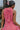 Back upper view of model wearing the Lost Without You Midi Dress that has a red and pink geometric pattern, a tiered skirt with a midi-length hem, and a draped neck that ties in the back.