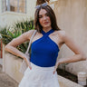  front view of model wearing The Primrose Halter Tank in cobalt blue. This tank has ribbed fabric and a halter cross strap neckline.