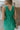 Close back view of model wearing the Make You Mine Midi Dress that has green plisse fabric, a midi-length hem, a v neck, thick straps, a sleeveless body, and a back zipper with a hook closure.