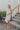 Full body front view of model wearing the Now and Forever Dress that has white fabric, a mini-length hem, a white lining, a round neckline, ruffle/elastic straps and a monochromatic side zipper.