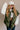Front view of model wearing the Big Sky Olive Green Oversized Puffer Vest which features olive green lightweight puffer fabric, an elastic hem, two front pockets, a monochromatic front zipper, a high neckline, and a sleeveless design.