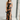 Full body view of model wearing the Athena Black Multi Floral Slit Maxi Dress which features black satin fabric with a red, orange, and green rose floral pattern, maxi length, a slit on the side, a cowl neckline, adjustable spaghetti straps, and an open b