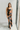 Full body view of model wearing the Athena Black Multi Floral Slit Maxi Dress which features black satin fabric with a red, orange, and green rose floral pattern, maxi length, a slit on the side, a cowl neckline, adjustable spaghetti straps, and an open b