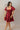 Full body front view of model wearing the Willow Burgundy Puff Sleeve Dress that has burgundy fabric, mini length, a tiered skirt, smocked chest, a square neck and short puff sleeves