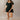 Full body front view of model wearing the Eliana Black Tiered Short Sleeve Romper that has black lightweight fabric, a ruffle-tiered skirt, black shorts lining, an elastic waistband, a sweetheart neckline and short puff sleeves.