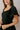 Close upper view of model wearing the Eliana Black Tiered Short Sleeve Romper that has black lightweight fabric, a ruffle-tiered skirt, black shorts lining, an elastic waistband, a sweetheart neckline and short puff sleeves.