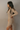 Side view of model wearing the Adeline Khaki Ribbed Long Sleeve Midi Dress which features khaki ribbed fabric, midi length, slits on each side, a square neckline, and long sleeves.
