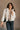 Front view of model wearing the Piper Off White Sherpa & Corduroy Jacket that has sherpa fabric, corduroy details, front snaps with a zipper, a high neck, pockets, and long sleeves.