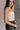 Side view of model wearing the Krista Cream Velvet Strapless Tube Top which features cream velvet fabric, a cropped waist, ruched side details, and a strapless sweetheart neckline.