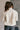 Back view of model wearing the view of model wearing the Piper Off White Sherpa & Corduroy Jacket that has sherpa fabric, corduroy details, front snaps with a zipper, a high neck, pockets, and long sleeves.