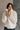front view of model wearing the view of model wearing the Piper Off White Sherpa & Corduroy Jacket that has sherpa fabric, corduroy details, front snaps with a zipper, a high neck, pockets, and long sleeves.