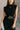 Close front view of model wearing the Lenora Black Knit High-Neck Midi Dress that has black knit fabric, midi length, a high neckline and a sleeveless design.