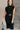 front view of model wearing the Lenora Black Knit High-Neck Midi Dress that has black knit fabric, midi length, a high neckline and a sleeveless design.