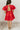 Full body back view of model wearing the Sophia Red Satin Short Puff Sleeves Mini Dress which features red satin fabric, mini length, plunge neckline, elastic wiastband, short puff sleeves and open back with pearl button closure.