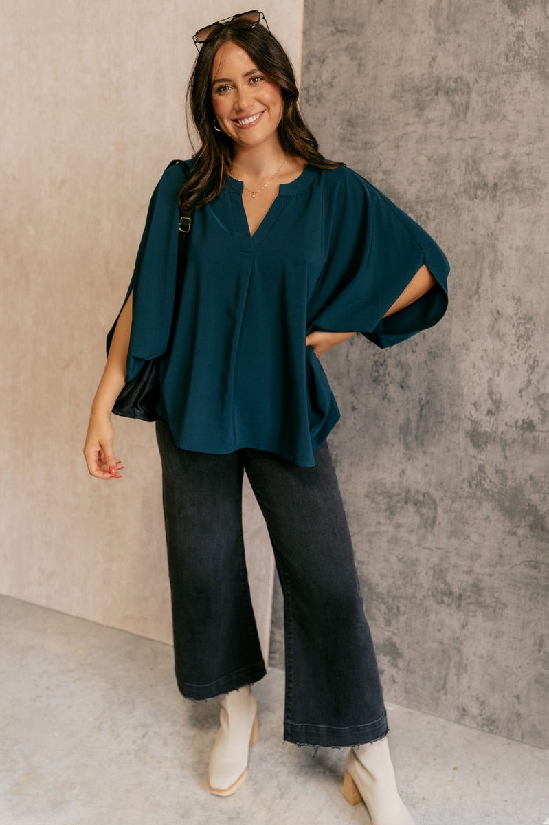 Full body view of model wearing the Grace Teal Oversized Short Sleeve Top which features teal lightweight fabric, an oversized fit, a round neckline with a v-cutout, and short dolman sleeves.