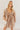 Front view of model wearing the Rosalie Cream Floral Long Sleeve Mini Dress that has cream lightweight fabric with a green and mustard floral print, a smocked upper, a plunge neck, and long puff sleeves.