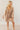 Full body front view of model wearing the Rosalie Cream Floral Long Sleeve Mini Dress that has cream lightweight fabric with a green and mustard floral print, a smocked upper, a plunge neck, and long puff sleeves.