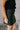 Side view of model wearing the Miley Black Rhinestone Faux Leather Mini Skirt which features black faux leather fabric, black lining, mini length, rhinestone embellishments, and a monochromatic side zipper with a hook closure.