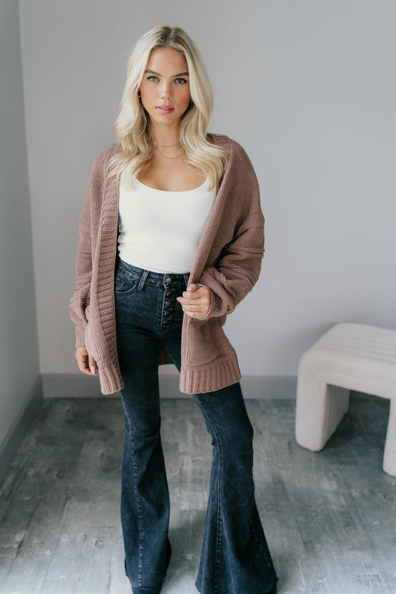 Full body front view of model wearing the Adaline Mocha Open Front Cardigan that has brown knit fabric, two front pockets, a front opening with no closure, dropped shoulders and long puff sleeves with cuffs.