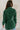 Back view of model wearing the Gianna Dark Green Button Front Dress that has dark green fabric, white stitch detailing, front button closures, a collared neck, chest pockets, and long sleeves. Worn open with white top.