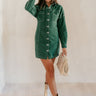 Full body front view of model wearing the Gianna Dark Green Button Front Dress that has dark green corduroy fabric, white stitch detailing, front button closures, a collared neck, chest pockets, and long sleeves.