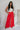 Full body view of model wearing the Scarlett Red Wide Leg Pants which features red lightweight fabric, two front pockets, a front zipper with a hook closure, belt loops and wide legs.