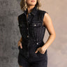 Front view of model wearing the Emily Washed Black Denim Sleeveless Romper which features washed black denim fabric, two front pockets, silver button details, button up front closure, two front chest buttoned pockets, two back pockets, collared neckline a