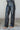 Frontal side body view of model wearing the Alexis Black Faux Leather Pants which features black faux leather, front zipper with button closure, two front pockets, two back pockets, belt loops and wide pant legs.