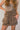 Front view of model wearing the Journey Mocha Brown Cargo Mini Skirt which features taupe brown textured soft fabric, two fornt cargo pocket with zipper closure, elastic waistband with tie and mini length.