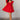 Full body view of model wearing the Aurora Red Floral Ruffle Mini Dress which features red fabric with a brown 3d floral pattern, a mini-length baby doll style, a v neckline, elastic straps with ruffles, and an open back with a bow detail.