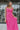 Front view of model wearing the Coastal Paradise Dress in Pink that has hot pink ribbed fabric, midi length, a round neckline, an elastic waistband, and spaghetti straps