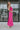 Full body side view of model wearing the Coastal Paradise Dress in Pink that has hot pink ribbed fabric, midi length, a round neckline, an elastic waistband, and spaghetti straps