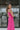 Side view of model wearing the Coastal Paradise Dress in Pink that has hot pink ribbed fabric, midi length, a round neckline, an elastic waistband, and spaghetti straps