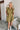 Frontal view of the Meet Your Match Dress that features a green colored material, a collar neckline, a button-up front, a ruffle sleeve, side pockets, and a mini length.